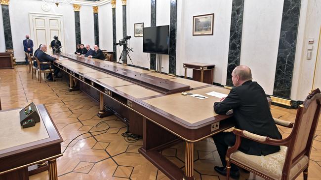 Keeping his distance: Vladimir Putin chairs a meeting in the Kremlin on Monday. Picture: AFP