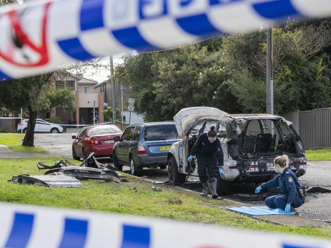 SYDNEY, AUSTRALIA - NCA NewsWire, SUNDAY, 14 AUGUST 2022: Forensics police officers examine the scene of a burnt out car in Revesby used to the fatal shootings of two women in Sydney's southwest. Picture: NCA NewsWire / Monique Harmer