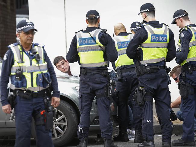 Police arrest a man across from Melbourne Assessment Prison. Picture: David Caird