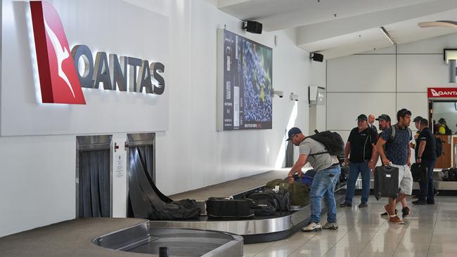 Qantas travellers retrieve bags from contractor belts at Adelaide Airport. Picture: Matt Loxton