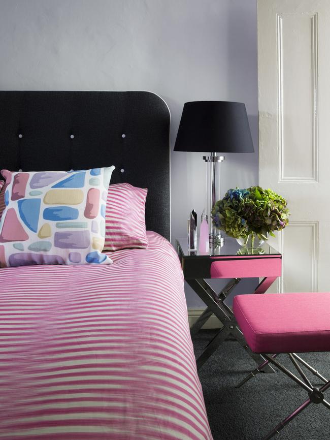 The pastel palette was continued upstairs by teaming a pink doona cover and ottoman with an upholstered bedhead in charcoal grey and white buttons.