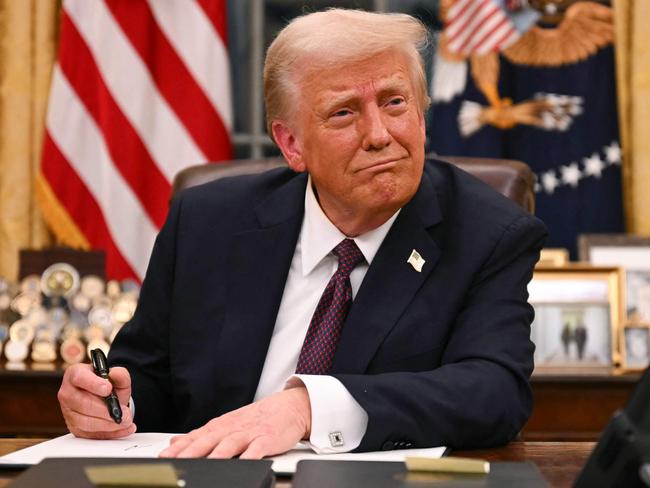 US President Donald Trump signs executive orders in the Oval Office of the White House in Washington, DC, on January 20, 2025. (Photo by Jim WATSON / POOL / AFP)