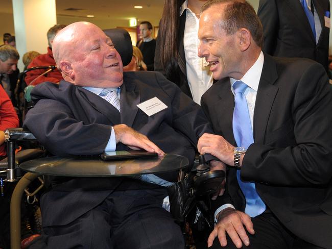 Former prime minister Tony Abbott, right, speaks with empowerment advocate John McKenna in 2014. Mr Abbott was at the opening of the National Disability Insurance Agency headquarters in Geelong. Picture: Julian Smith/AAP