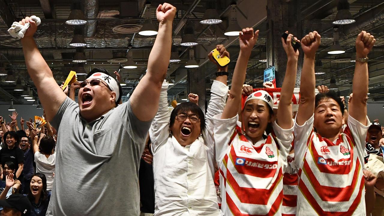 Japan fans celebrate at the "fanzone" area in Tokyo on October 13, 2019, during the Japan 2019 Rugby World Cup Pool A match between Japan and Scotland in Yokohama. (Photo by Anne-Christine POUJOULAT / AFP)