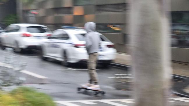 Mr Bruce zipped up a side street on the longboard, which may have been motorised. Picture: NCA NewsWire / Anthony Anderson