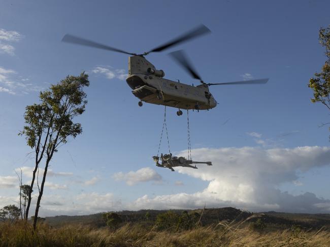 An Australian Army CH-47 Chinook from the 5th Aviation Regiment prepares to unload a M777 howitzer during Exercise Chau Pha in Townsville Field Training Area, Queensland.