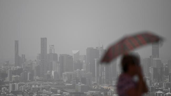 A visitor to the Mt Coottha lookout looks on as smoke haze blankets central Brisbane. Picture: AAP