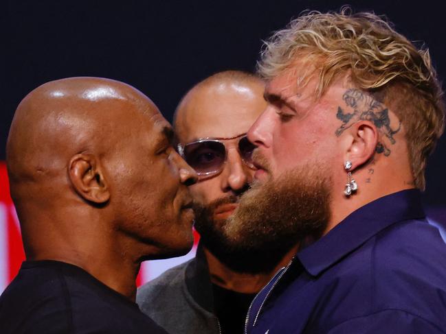 (FILES) Former US boxer Mike Tyson (L) and YouTuber Jake Paul face off during a press conference at the Apollo Theatre in New York, on May 13, 2024. Mike Tyson's upcoming return to the ring against YouTuber Jake Paul has been postponed after the former heavyweight champion's recent health scare, organisers said on May 31, 2024. (Photo by Kena Betancur / AFP)