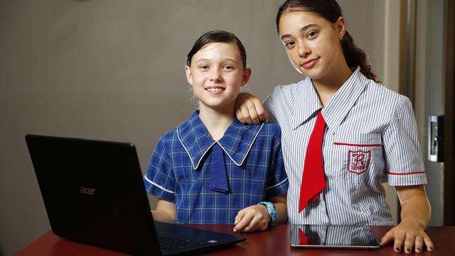 Jessica Gibbs, 10, and Jordyn Gibbs, 15, with their devices. Picture: AAP/Josh Woning