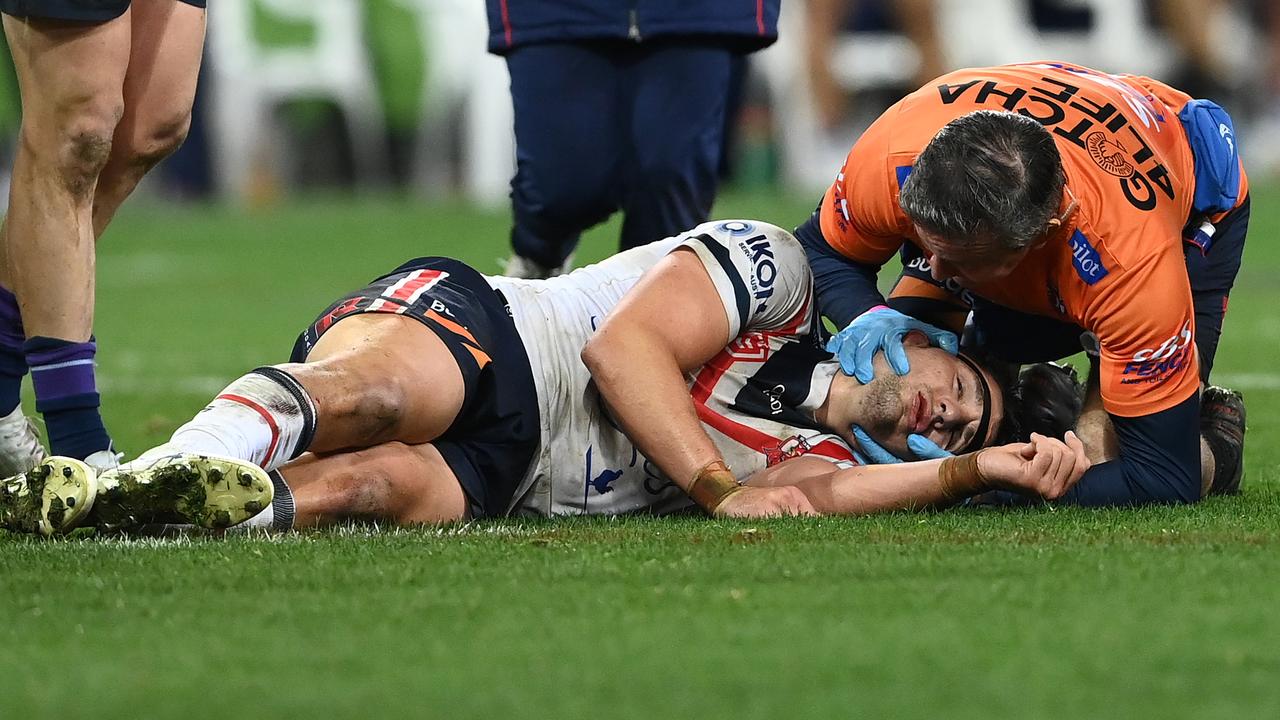 Victor Radley of the Roosters is attended to by a team trainer. Photo by Quinn Rooney/Getty Images