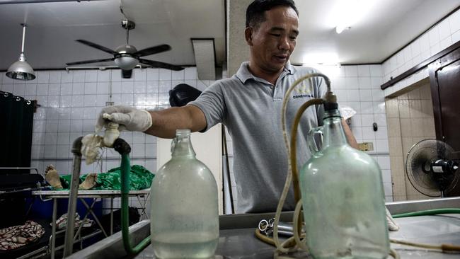 Embalmer Alejandro Ormeneta preparing embalming instruments before operating on a body inside the morgue of Veronica Memorial Chapel in Manila. Picture: AFP / Noel Celis.