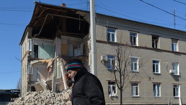 An elderly woman walks past a building partially destroyed after shelling on the northern outskirts of Kharkiv. Picture: AFP.