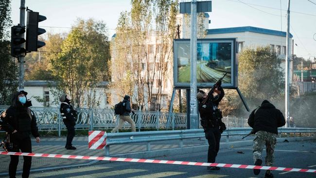 A police officer fires at a flying drone following attacks in Kyiv. Picture: AFP