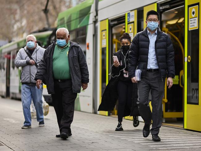 MELBOURNE, AUSTRALIA - JULY 14: Members of the public wear face masks as they commute around the city on July 14, 2022 in Melbourne, Australia. Victorian Health authorities are recommending residents resume wearing face masks indoors as COVID-19 infections begin to rise again across Australia. (Photo by Graham Denholm/Getty Images)