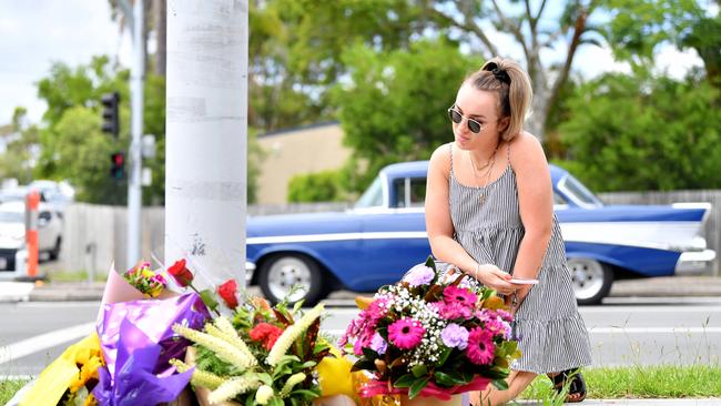 A mourner pauses after placing flowers at a makeshift shrine where a couple walking their dog were hit and killed in a crash involving an allegedly stolen car at Alexandra Hills in Brisbane's east. Picture: NCA NewsWire / Dan Peled