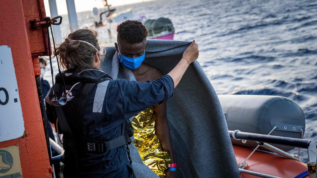 A migrant who was just helped off the rescue ship funded by British street artist Banksy "Louise Michel" is covered with a blanket on board the civil sea rescue ship Sea-Watch 4 off the coast of Malta, on August 29, 2020. Picture: Thomas Lohnes / AFP