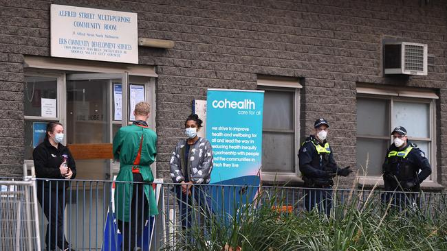 Police and medical workers stand outside an entrance to a public housing estate during a forced lockdown in Melbourne, as the city clocks up the highest number of active cases of any LGA, with 229. Picture: AFP