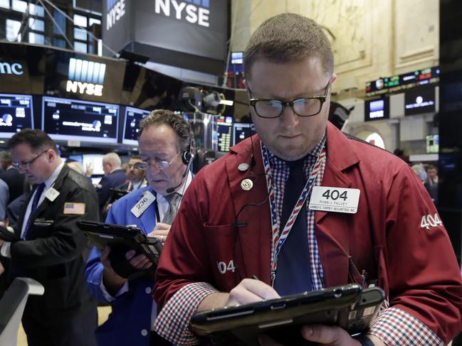 Trader Ryan Falvey, center, on the floor of the New York Stock Exchange, Monday, April 11, 2016. U.S. stocks opened higher on Wall Street following gains overseas as investors held out hope for more economic stimulus from China. (AP Photo/Richard Drew)