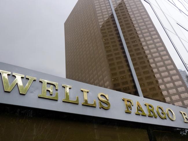 FILE - In this May 5, 2015, file photo, a downtown building is reflected in the windows of a Wells Fargo Bank in Los Angeles. Wells Fargo reports financial results on Friday, July 15, 2016. (AP Photo/Richard Vogel, File)
