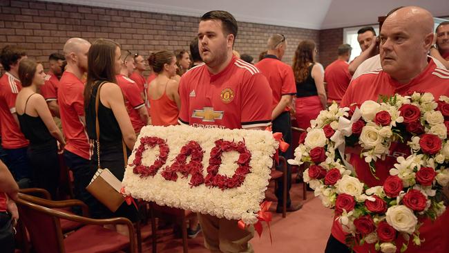 Dominic Delaney carries a ‘Dad’ flower bed at the funeral of Carl Delaney. Pictures: MICHAEL FRANCHI