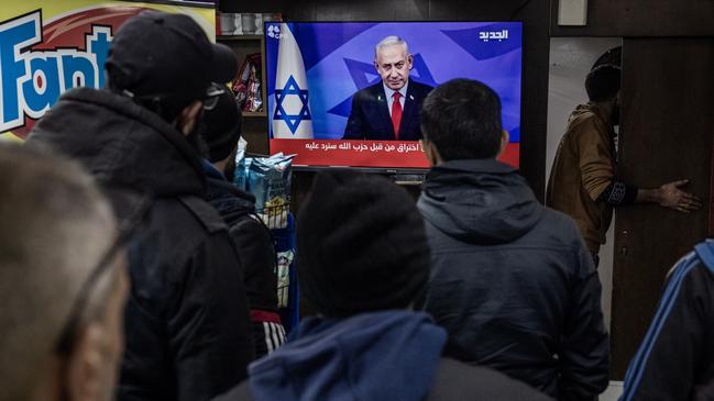 People watch television in Beirut as Israeli Prime Minister Benjamin Netanyahu announces a ceasefire. Picture: Getty Images