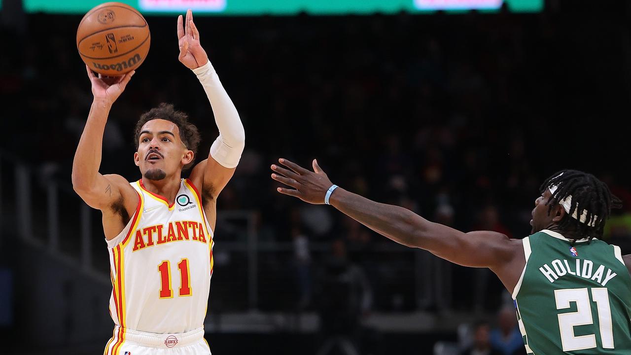 ATLANTA, GEORGIA - NOVEMBER 14: Trae Young #11 of the Atlanta Hawks shoots a three-point basket against Jrue Holiday #21 of the Milwaukee Bucks during the first half at State Farm Arena on November 14, 2021 in Atlanta, Georgia. NOTE TO USER: User expressly acknowledges and agrees that, by downloading and or using this photograph, User is consenting to the terms and conditions of the Getty Images License Agreement. Kevin C. Cox/Getty Images/AFP == FOR NEWSPAPERS, INTERNET, TELCOS &amp; TELEVISION USE ONLY ==
