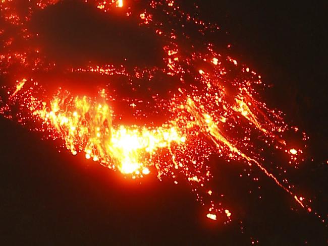 Lava flows down the slopes of Mayon volcano as it erupts anew, as seen from Legazpi city, Albay province around 200 miles (340 kilometers) southeast of Manila, Philippines Friday, Jan. 26, 2018. The Philippine Institute of Volcanology and Seismology Chief Renato Solidum said a "still significant of magma has risen in the upper part of the volcano, indicating a still possible explosion will be more powerful than what is being shown right now." Mayon's lava fountaining has flowed up to 3 kilometers (1.86 miles) from the crater in a dazzling but increasingly dangerous eruption.(AP Photo/Bullit Marquez)