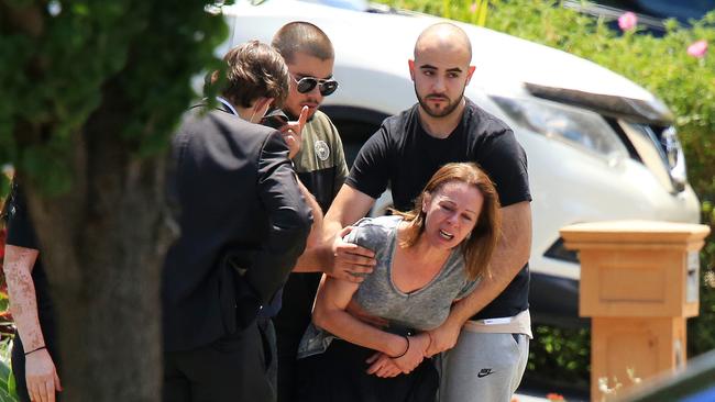 A woman believed to be the deceased’s mother is helped as a coroner’s van leaves the scene. Picture: Mark Stewart