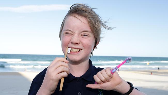 Ned Heaton, 11, of Tamborine Mountain, on the beach with a bamboo and a plastic tooth brush.