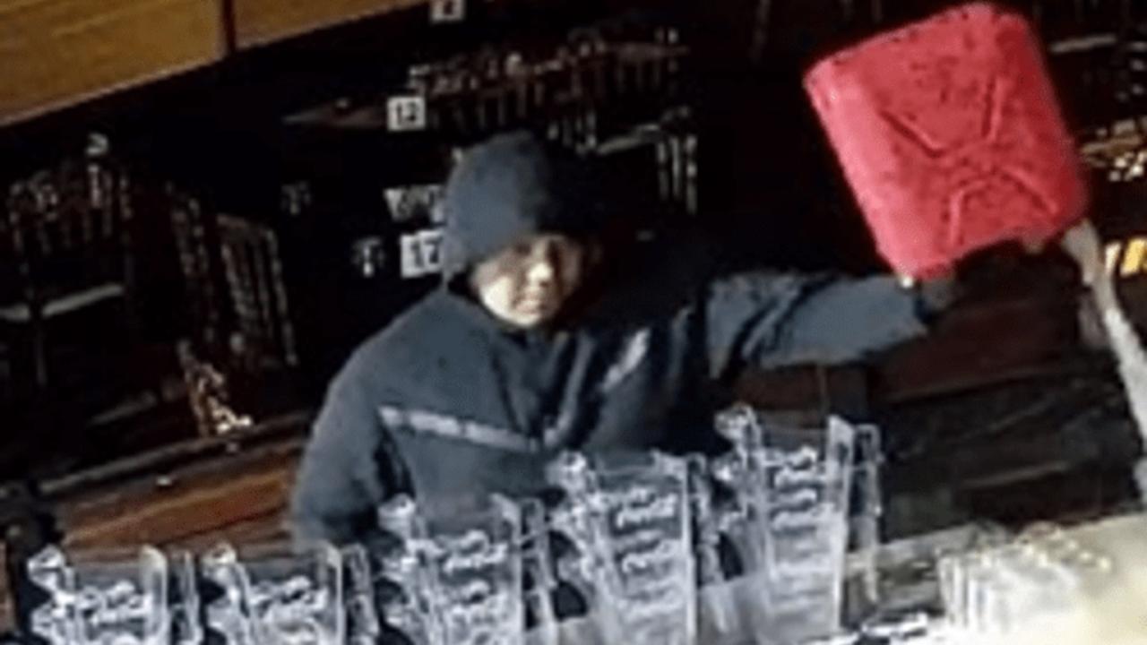 The man, dressed in black with his hood pulled up, then pours accelerant out of a red jerry can across the floor of the Al Marjan restaurant and the bar, slipping and sliding around in the process.