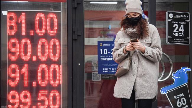 A woman walks past a currency exchange office in central Moscow on February 24, 2022. - Russia's central bank said Thursday in would intervene as the ruble tumbled to a record low and the Moscow Stock Exchange reopened down 14 percent after Moscow launched a military attack on Ukraine, as Russian President Vladimir Putin announced a military operation in Ukraine on Thursday with explosions heard soon after across the country and its foreign minister warning a "full-scale invasion" was underway. (Photo by Alexander NEMENOV / AFP)