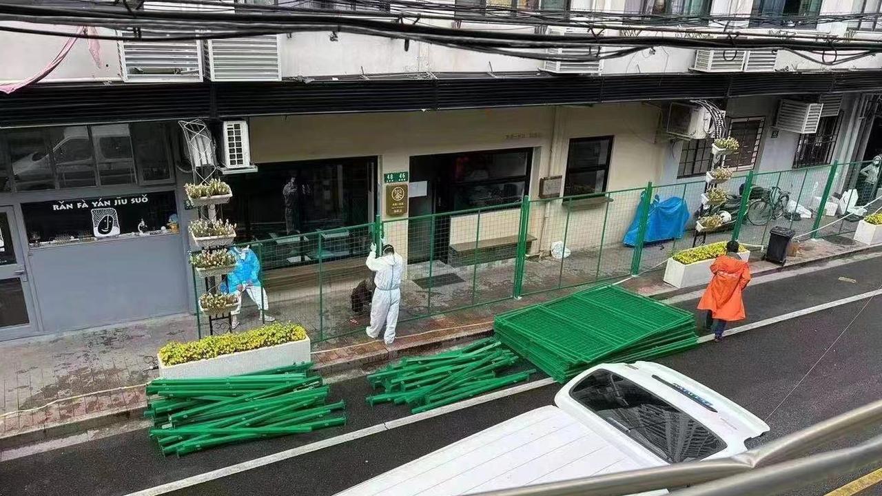 This image shows a cafe being boarded up with green fencing. Picture: Twitter/Chris Pc