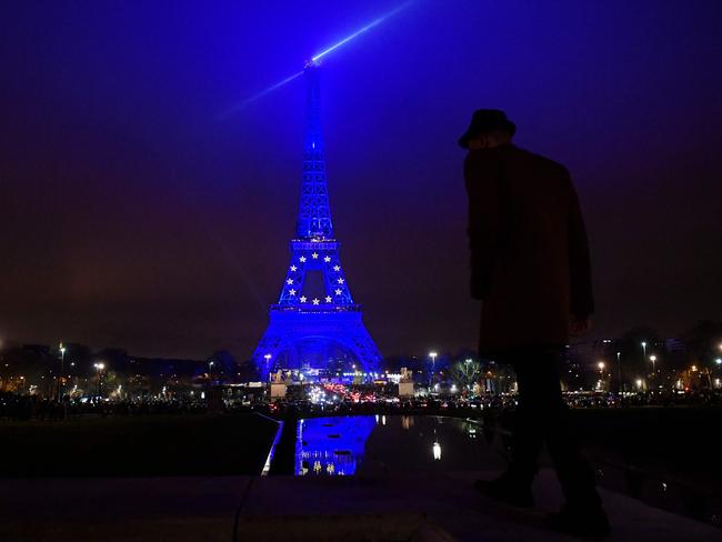 A man walks in front of the Eiffel Tower lit up in blue to mark the French presidency of the European Union during New Year's Eve in Paris. Picture: AFP