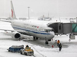 Workers clear snow at the Capital International Airport in Beijing, China, Sunday. Picture: AP