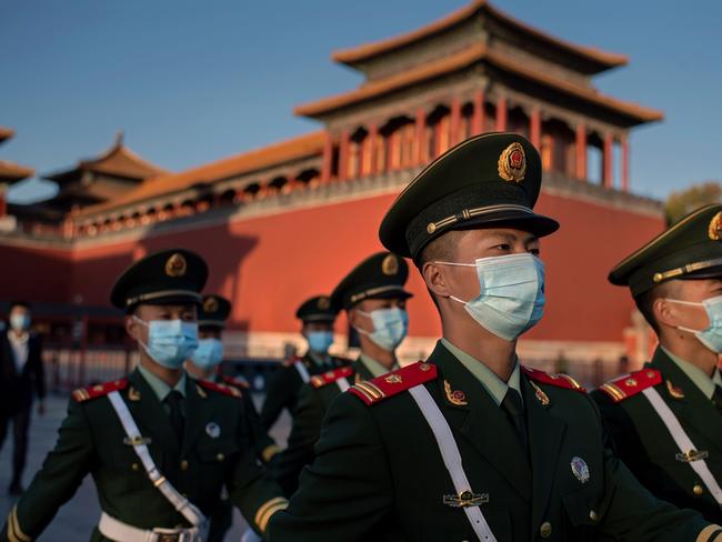 Paramilitary police officers wearing face masks march outside the Forbidden City in Beijing on October 22, 2020, on the eve of the 70th anniversary of Chinaâs entry into the 1950-53 Korean War. (Photo by NICOLAS ASFOURI / AFP)