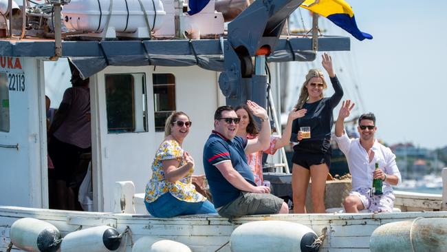 People enjoy champagne and the sun on one of the tugboats. Picture: Thomas Lisson