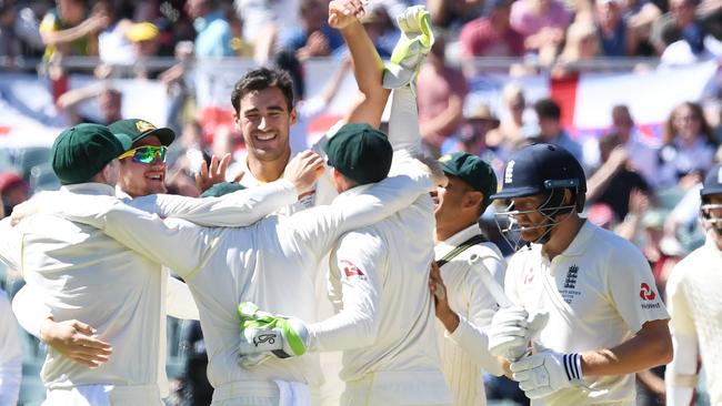 Australia's Mitchell Starc celebrates with his team mates, as England's Jonny Bairstow walks from the pitch, after defeating England on Day 5 of the Second Test match between Australia and England at the Adelaide Oval in in Adelaide, Wednesday, December 6, 2017.  (AAP Image/Dean Lewins) NO ARCHIVING, EDITORIAL USE ONLY, IMAGES TO BE USED FOR NEWS REPORTING PURPOSES ONLY, NO COMMERCIAL USE WHATSOEVER, NO USE IN BOOKS WITHOUT PRIOR WRITTEN CONSENT FROM AAP