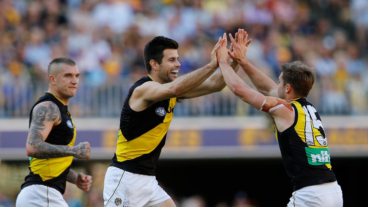 Dustin Martin and Trent Cotchin celebrate a goal with Jayden Short this year.