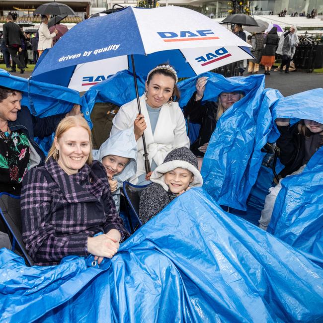 The Newitt family uses a tarp to shelter from the rain. Picture: Jake Nowakowski