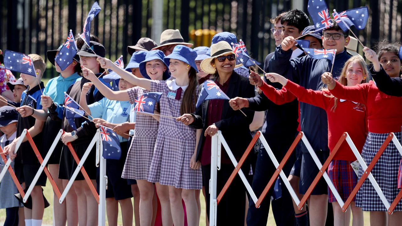 Local schoolchildren wave flags as King Charles III and Queen Camilla arrive in Canberra on Monday during their first visit to Australia as monarchs. Picture: Chris Jackson/Getty Images