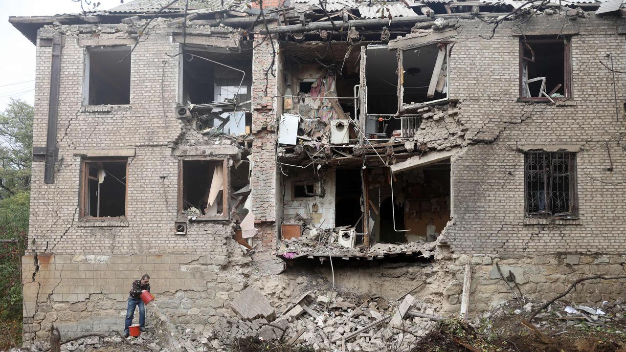 A local resident clean debris next to a residential building destroyed by a missile strike in Konstantinovka in the eastern Donetsk region. Picture: AFP