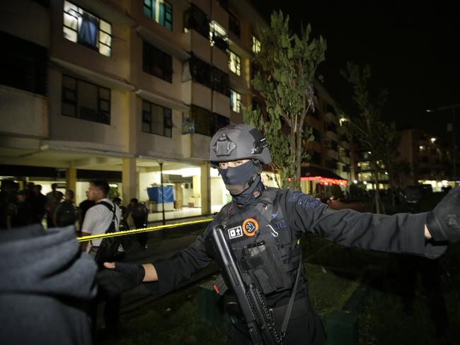 Indonesian police clear the area in front of an apartment building after an explosion in Sidoarjo, East Java. Picture: AP