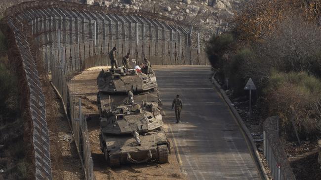 Israeli soldiers stand near tanks near the border with Syria in the Golan Heights. Picture; Getty Images.