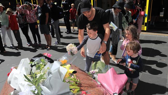 Young children lay flowers at Bourke St Mall. Picture: Alex Coppel