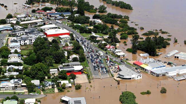 Cars stuck along a street as floodwaters surround Gympie on Sunday. Picture: Getty Images