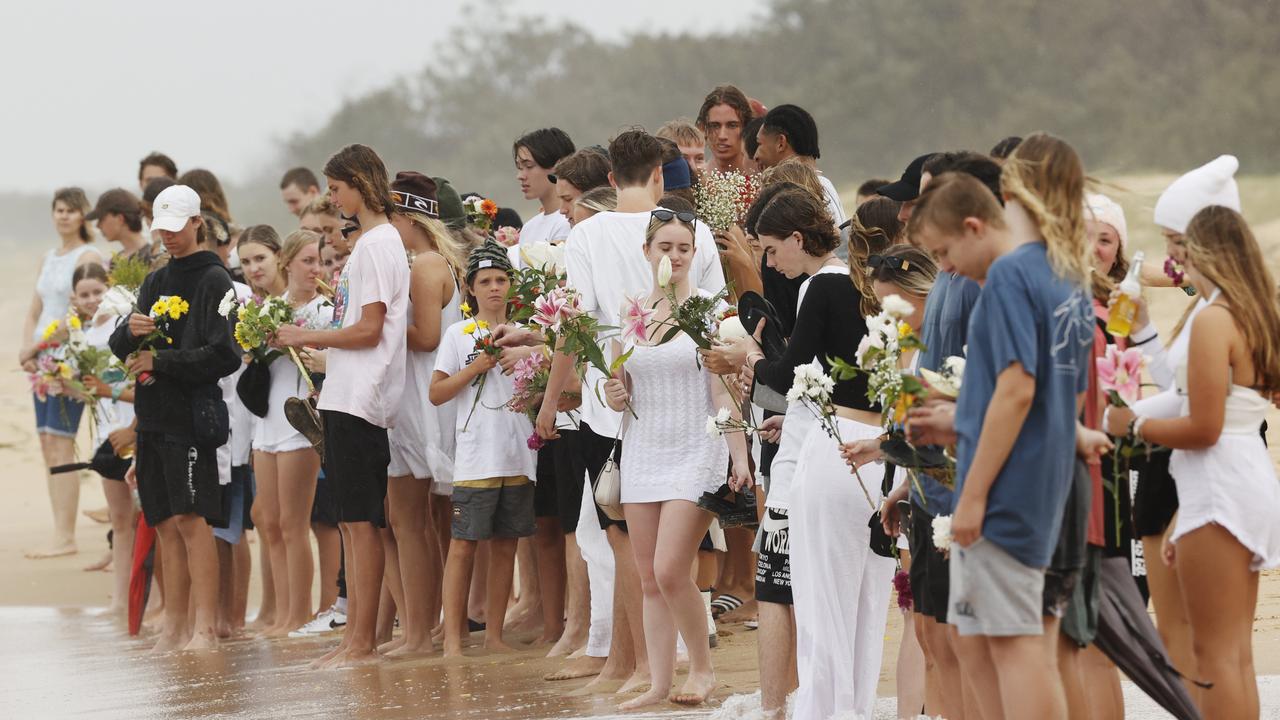 Family and friends of 16-year-old alleged stabbing victim Balin Stewart gather to pay tribute on his home beach at Buddina. Picture: Lachie Millard