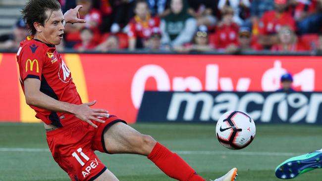 Craig Goodwin slots the ball past Victory goalkeeper Lawrence Thomas to score for Adelaide United last night. Picture: AAP