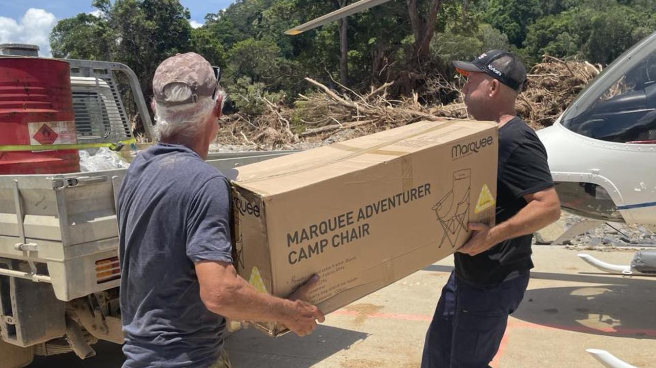 Degarra residents Philip Carlton and Perry Gould load emergency supplies from a Nautilus helicopter to a ute, where they were transported to the home of another local for temporary storage because there is no recovery operations centre. Picture: Bronwyn Farr