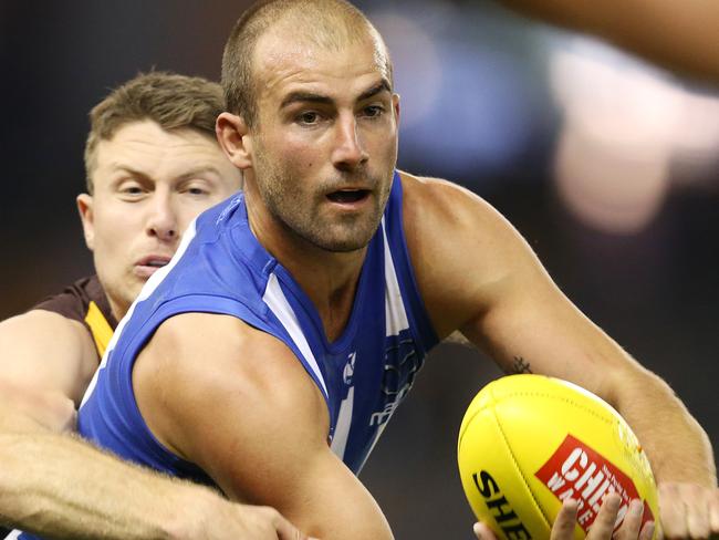 AFL Round 5. 22/04/2018. North Melbourne v Hawthorn at Etihad Stadium.  North Melbourne's Ben Cunnington clears by hand  . Pic: Michael Klein