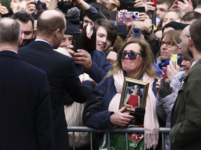 Prince William talks to a fan, holding a photo of his mother, during a visit to Galway. Picture: AP